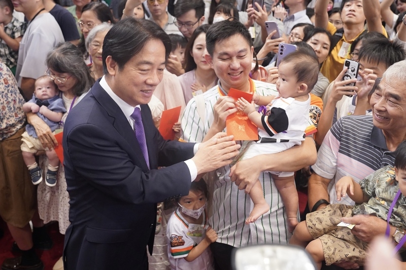 總統賴清德主持113年總統府暨國家安全會議員工家庭日，發放紅包給帶嬰幼兒前來的員工。（中央社記者徐肇昌攝）