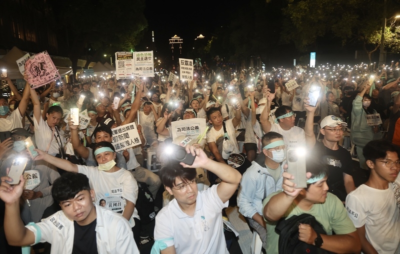 民眾黨8日晚間在立法院旁的濟南路發起首場公民開講活動，捍衛黨主席柯文哲清白與程序正義，支持者頭上綁著藍綠色布條，現場亮起手機燈光聲援。（中央社提供）