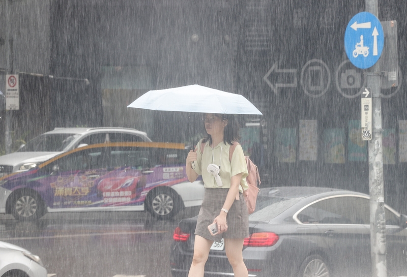 民眾撐傘擋雨。( 中央社記者謝佳璋攝）