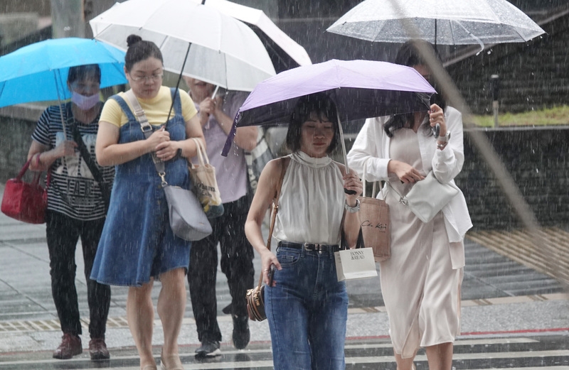 圖為南港地區民眾外出撐傘擋雨。 （中央社記者鄭傑文攝）