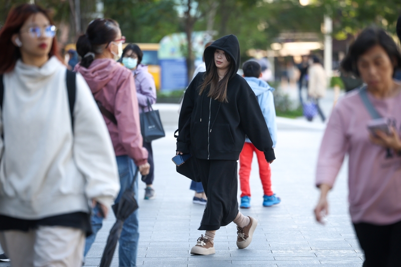 圖為走在新北市板橋區街頭的民眾穿外套與厚衣服禦寒。（中央社記者王騰毅攝）