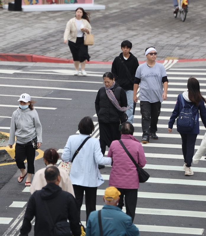 圖為新北市板橋區，路上行人穿著外套、保暖衣物。（中央社記者趙世勳攝）