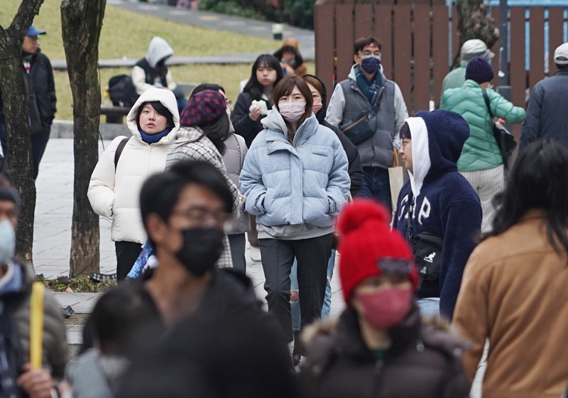 圖為台北市中山區下午出現逛街人潮，民眾穿外套、戴帽子禦寒。 (中央社記者裴禛攝)